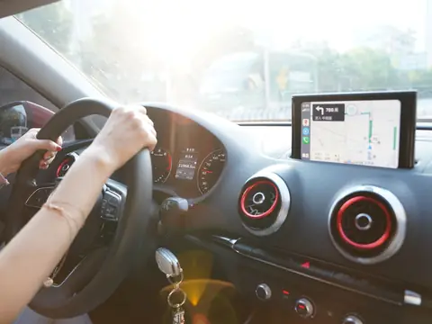 Hands on the wheel with a map on the dash screen